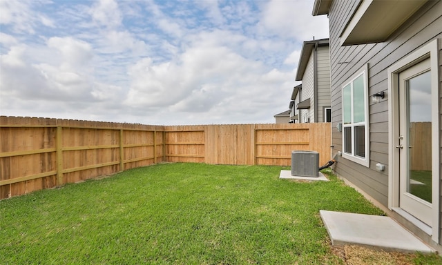 view of yard with central AC and fence