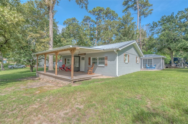 rear view of property featuring a wooden deck and a yard