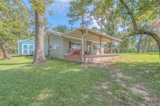 view of front facade with a front lawn, covered porch, and a storage shed