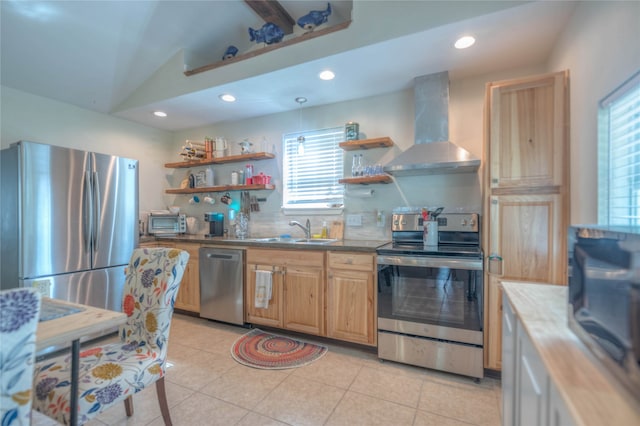 kitchen with lofted ceiling, wall chimney range hood, sink, decorative backsplash, and appliances with stainless steel finishes