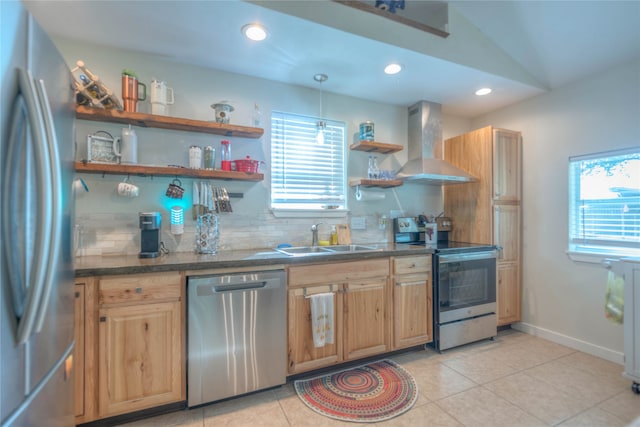 kitchen featuring sink, wall chimney range hood, tasteful backsplash, vaulted ceiling, and appliances with stainless steel finishes