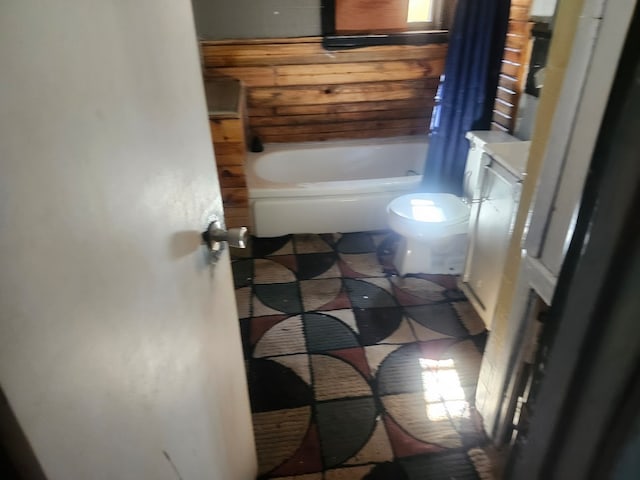 bathroom with vanity, a tub, and toilet