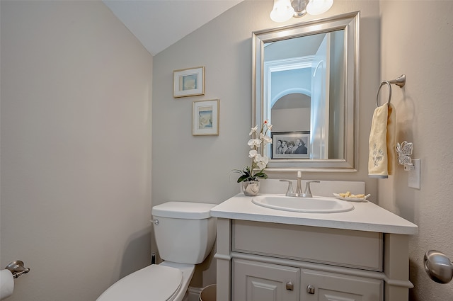 bathroom featuring vaulted ceiling, toilet, and vanity