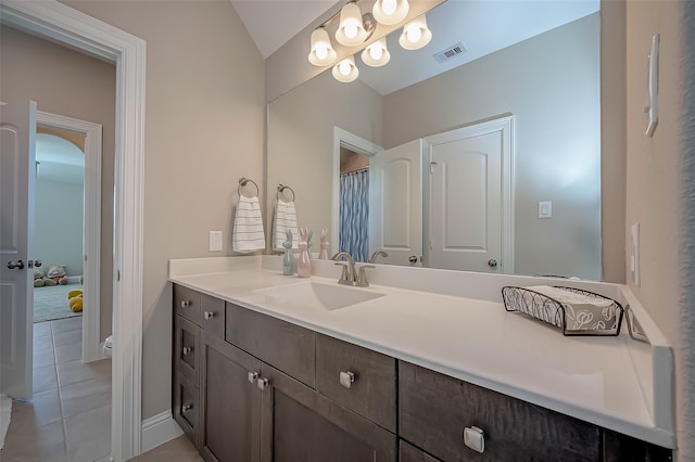 bathroom featuring lofted ceiling, tile patterned floors, vanity, and toilet