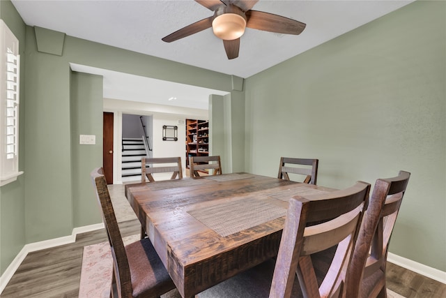 dining space featuring dark wood-type flooring and ceiling fan