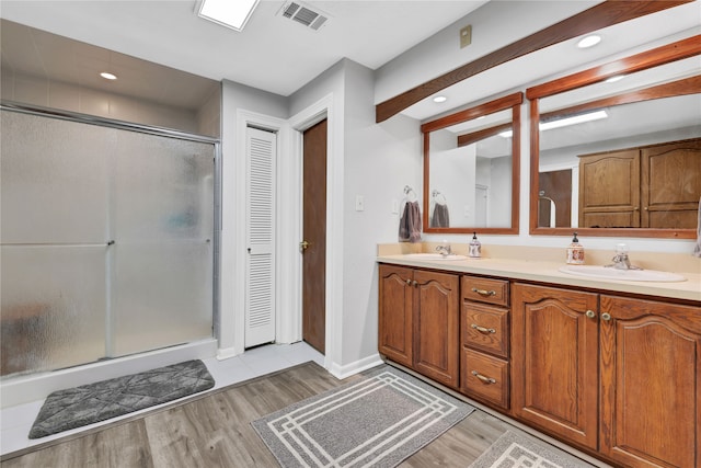 bathroom with vanity, hardwood / wood-style floors, and a shower with door