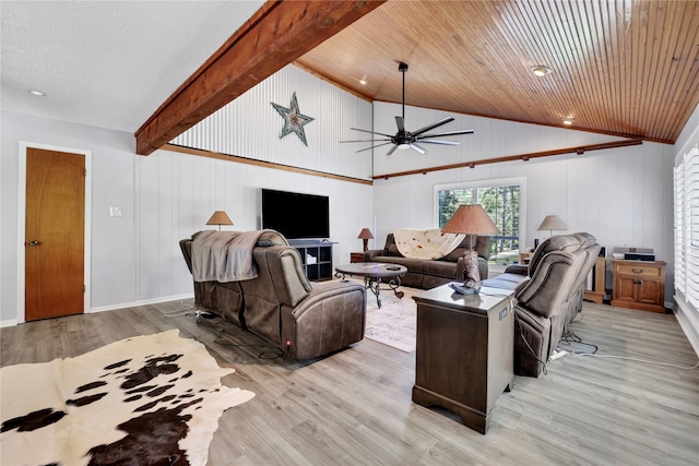 living room featuring ceiling fan, a fireplace, vaulted ceiling with beams, and light hardwood / wood-style flooring