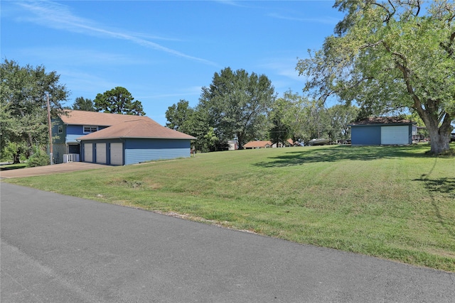 view of yard with a garage and an outbuilding