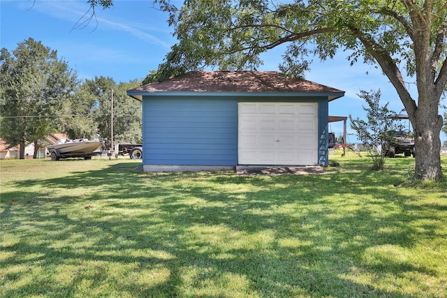 view of outdoor structure with a yard and a garage