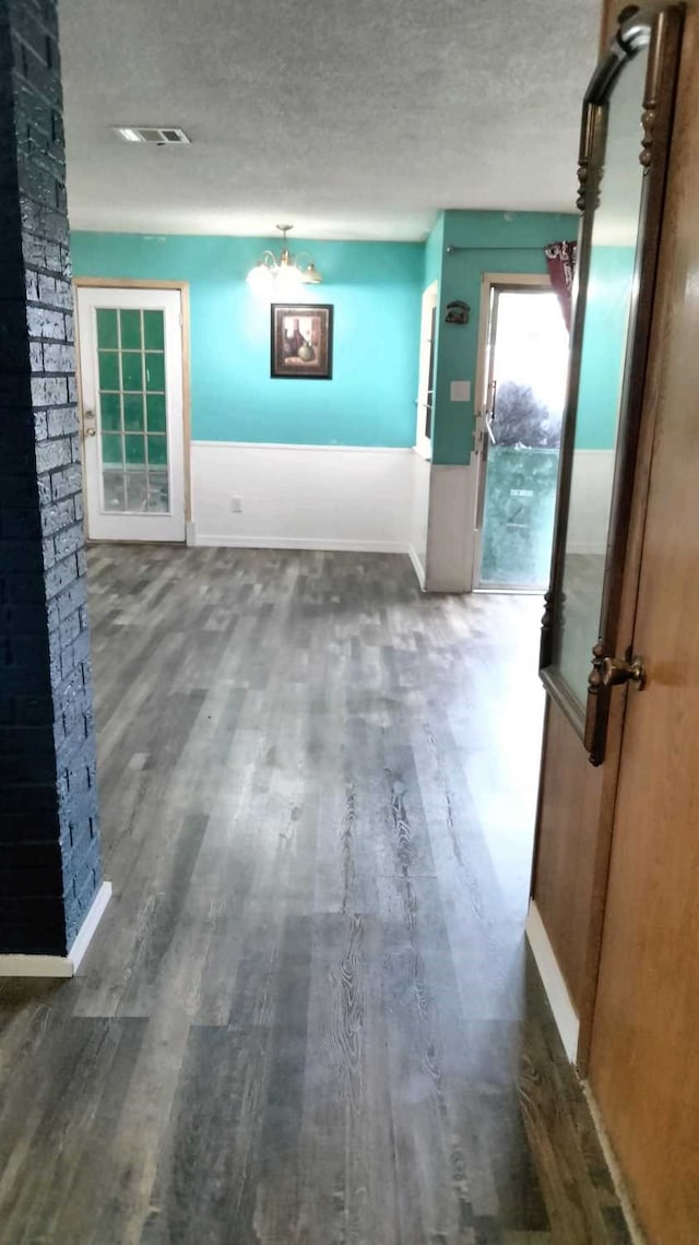 interior space featuring a textured ceiling and dark hardwood / wood-style floors