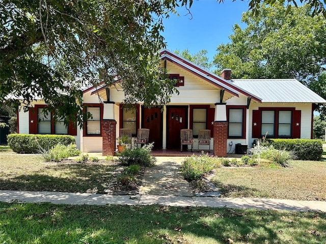 view of front of property with covered porch and a front yard