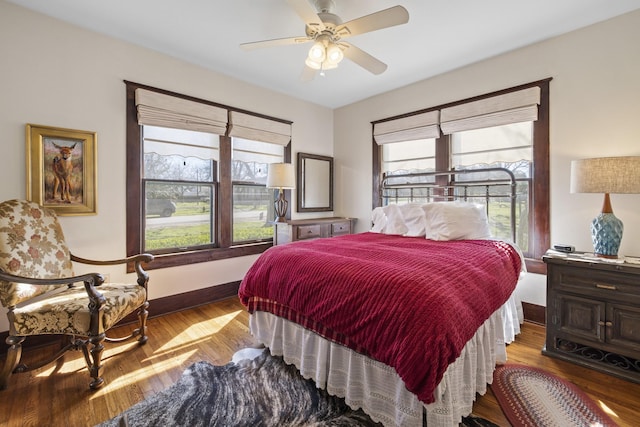 bedroom with multiple windows, light hardwood / wood-style flooring, and ceiling fan