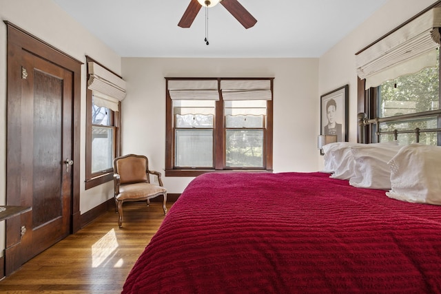 bedroom with multiple windows, ceiling fan, and hardwood / wood-style flooring