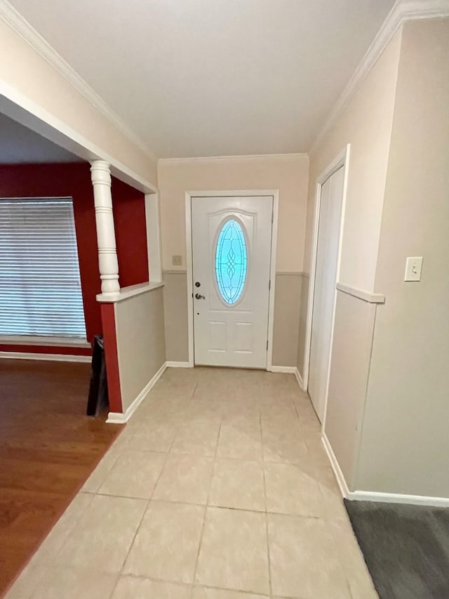 foyer entrance with light wood-type flooring, ornate columns, and ornamental molding