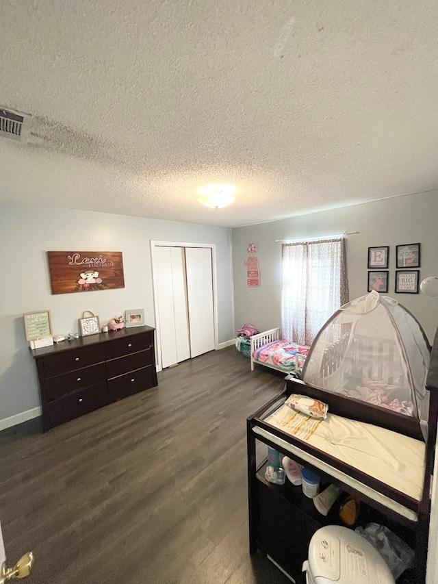 bedroom featuring a closet, dark hardwood / wood-style floors, and a textured ceiling