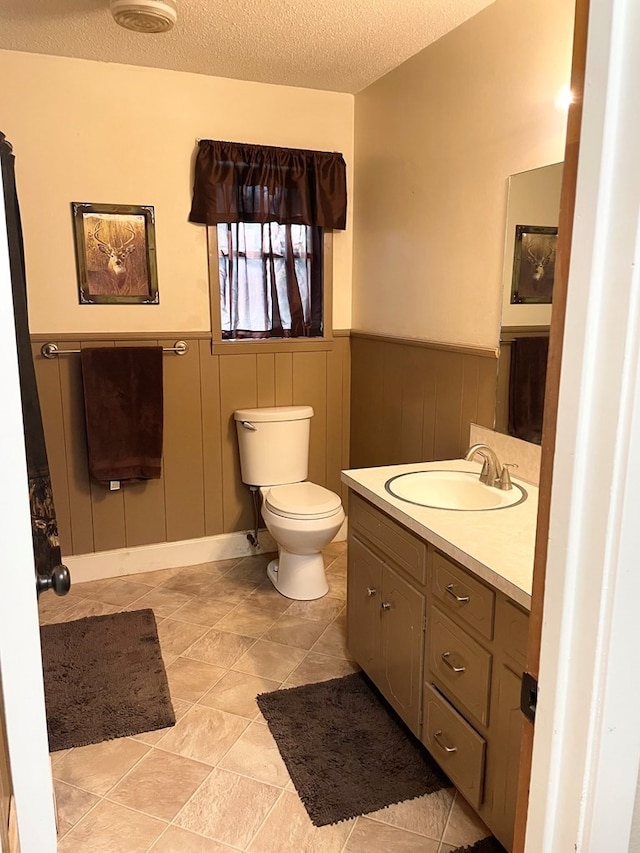 bathroom featuring vanity, toilet, and a textured ceiling