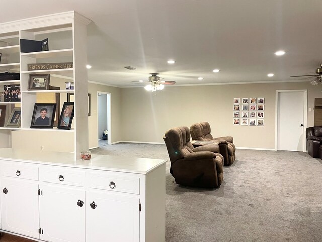 sitting room with ornamental molding, ceiling fan, and carpet flooring