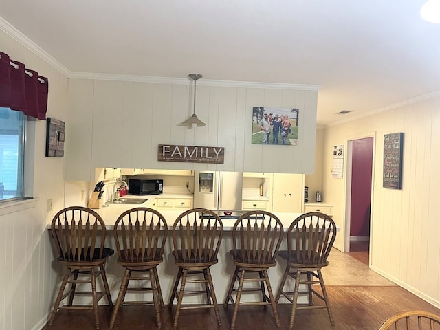 kitchen with crown molding, pendant lighting, dark hardwood / wood-style flooring, and stainless steel refrigerator with ice dispenser