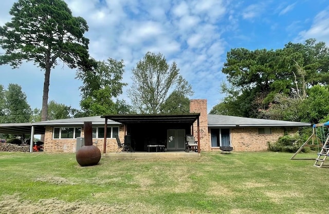 back of property with a playground and a yard