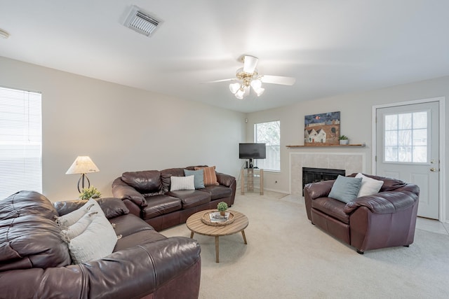 carpeted living room featuring plenty of natural light, ceiling fan, and a fireplace