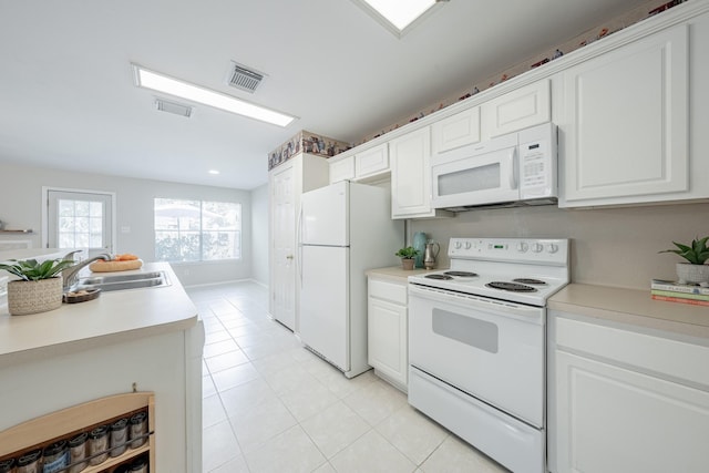 kitchen featuring sink, white appliances, and white cabinets