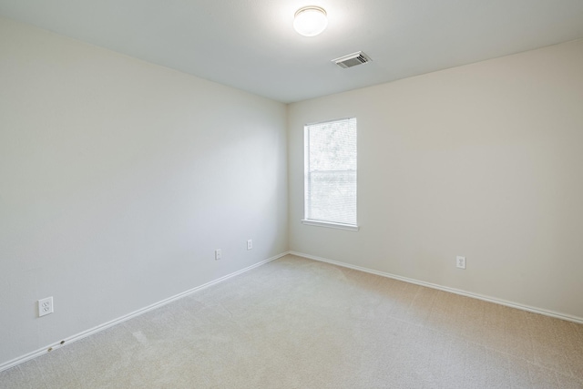 spare room featuring light colored carpet