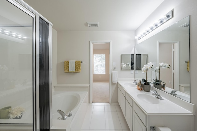 bathroom featuring a bathing tub, vanity, and tile patterned flooring