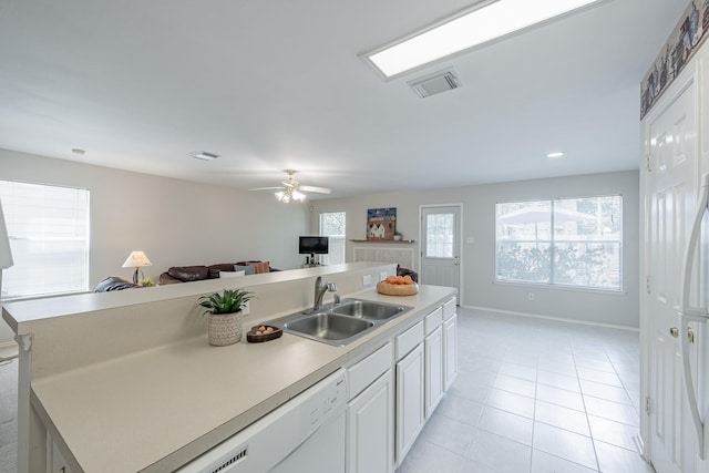 kitchen with a center island with sink, light tile patterned floors, sink, and white cabinets