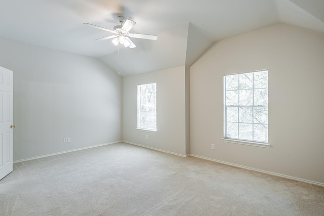 carpeted spare room featuring ceiling fan and vaulted ceiling