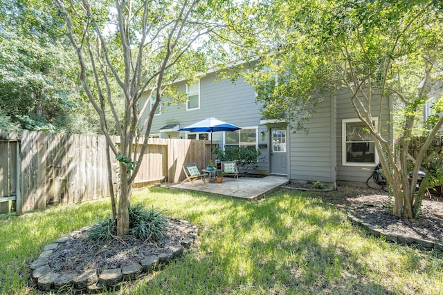 rear view of house featuring a yard and a patio area