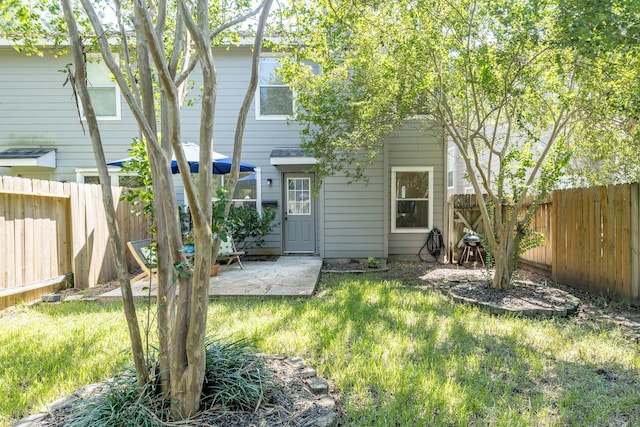 rear view of property featuring a yard and a patio area