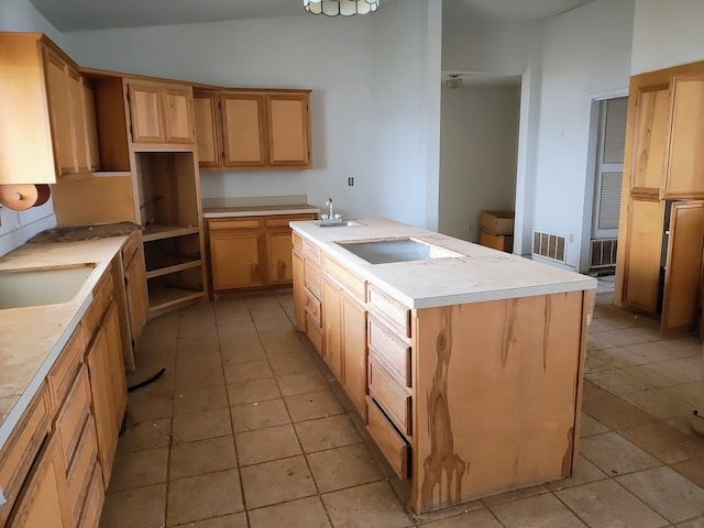 kitchen featuring vaulted ceiling, black electric stovetop, an island with sink, and sink