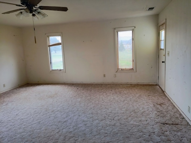 carpeted empty room with plenty of natural light and ceiling fan