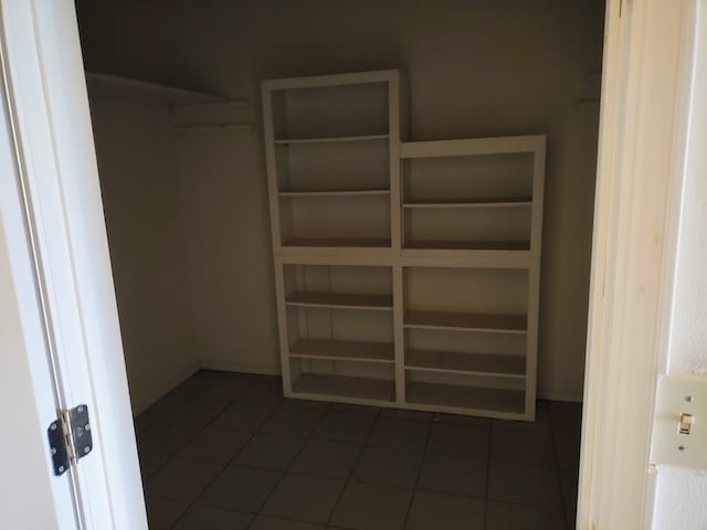 walk in closet with dark tile patterned flooring