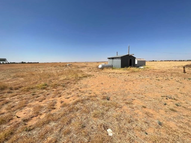 view of yard with an outdoor structure and a rural view