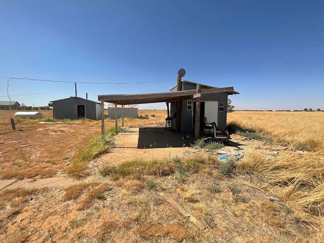 view of outbuilding with a rural view and a carport