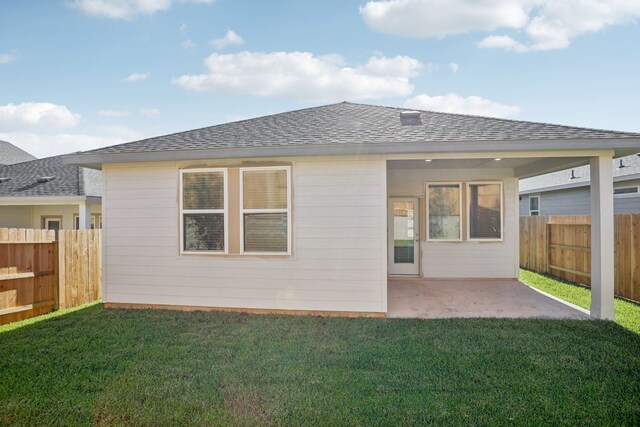 rear view of house with a patio and a yard