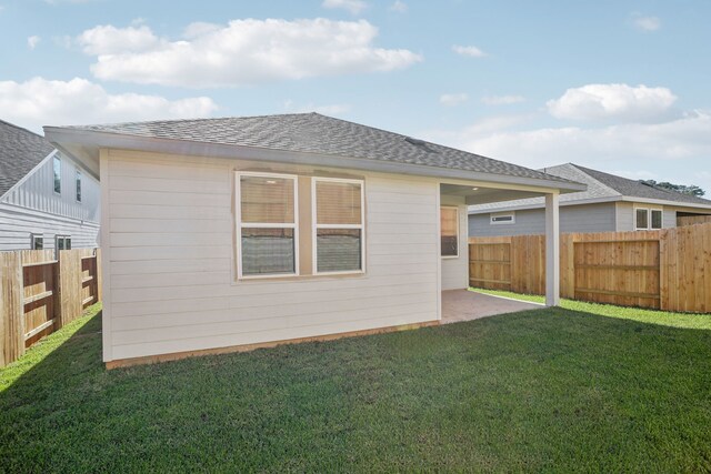 back of house featuring a patio area and a yard