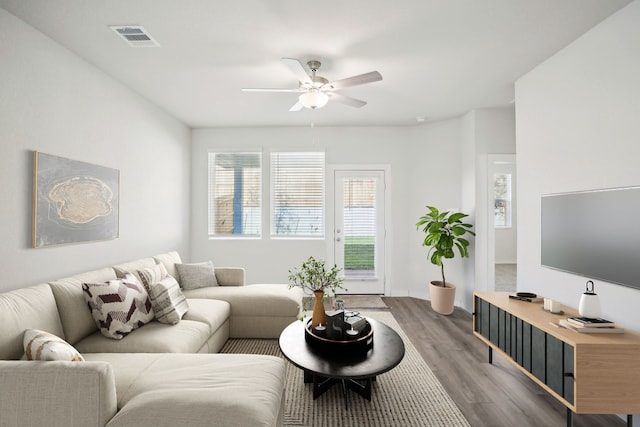 living room featuring wood-type flooring and ceiling fan