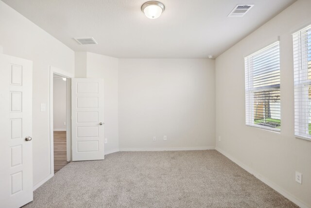 carpeted spare room featuring a healthy amount of sunlight