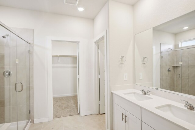 bathroom with tile patterned flooring, a shower with shower door, and vanity