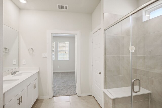 bathroom featuring a shower with door, tile patterned floors, and vanity