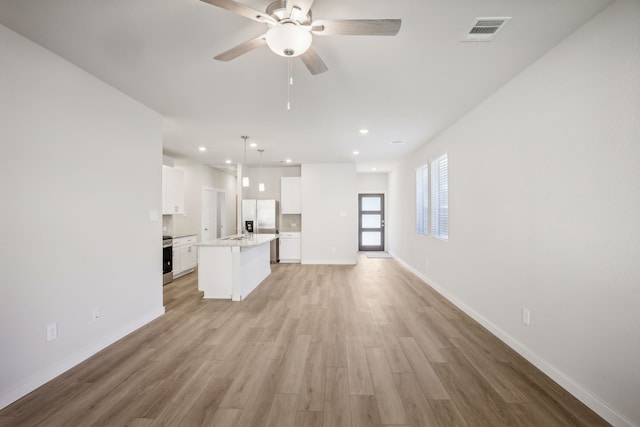 unfurnished living room with ceiling fan and light hardwood / wood-style floors