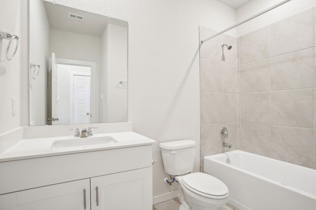 full bathroom with toilet, vanity, and tiled shower / bath