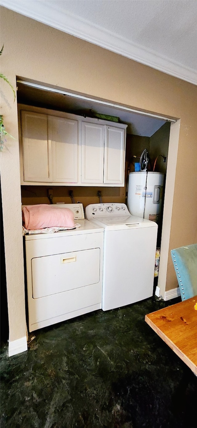 clothes washing area with ornamental molding, washing machine and clothes dryer, cabinets, and electric water heater