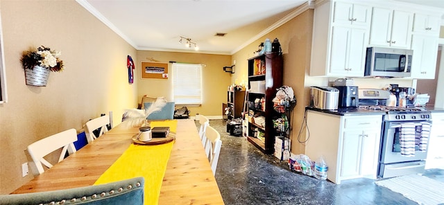 kitchen featuring ornamental molding, appliances with stainless steel finishes, white cabinetry, and hardwood / wood-style floors