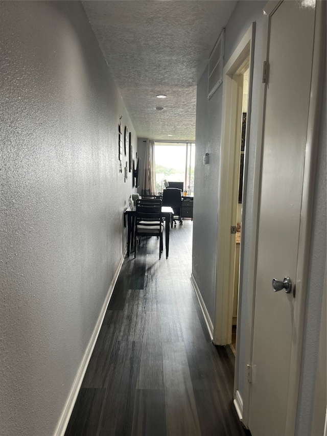 hall featuring a textured ceiling and dark hardwood / wood-style floors