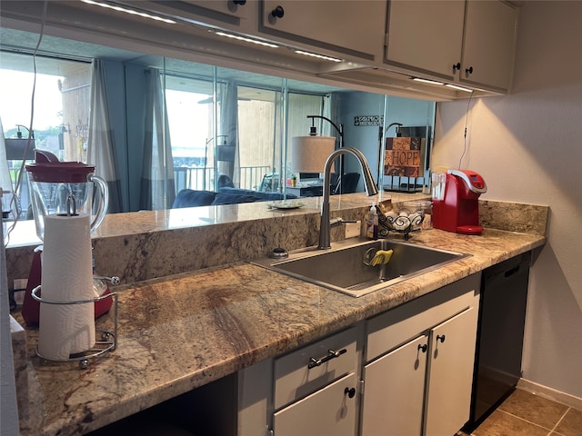 kitchen featuring tile patterned flooring, dishwasher, plenty of natural light, and sink