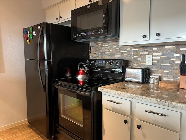 kitchen featuring light tile patterned floors, light stone countertops, white cabinetry, black appliances, and decorative backsplash