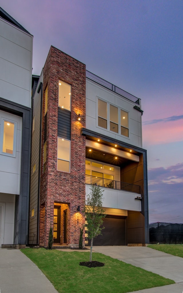 contemporary house featuring a balcony and a lawn